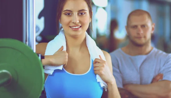 Schöne Frau im Fitnessstudio beim Training mit ihrem Trainer — Stockfoto