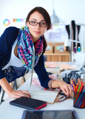 Giysi tasarımcısı kağıt üzerinde kıyafet deseni tasarlıyor