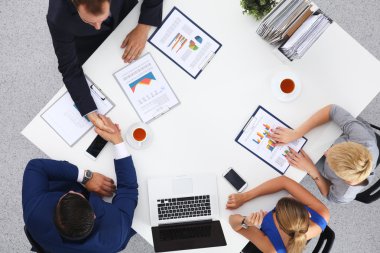 İş adamları iş toplantısında, ofiste oturup tartışıyorlar.