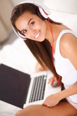 Genç güzel kadın yatakta müzik