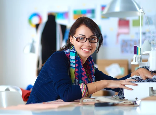 Mujer joven cosiendo sentado en su lugar de trabajo —  Fotos de Stock