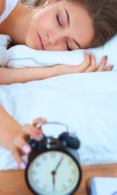 Genç bir kadın sabah alarmını erteliyor.