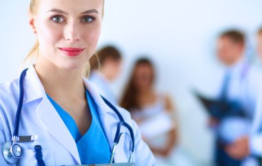 Kadın doktor hastanede dosyayla bekliyor.