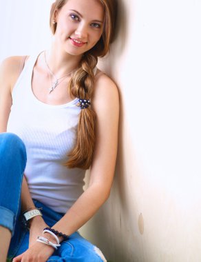 çimenlerin üzerinde kitapla oturan genç kadın