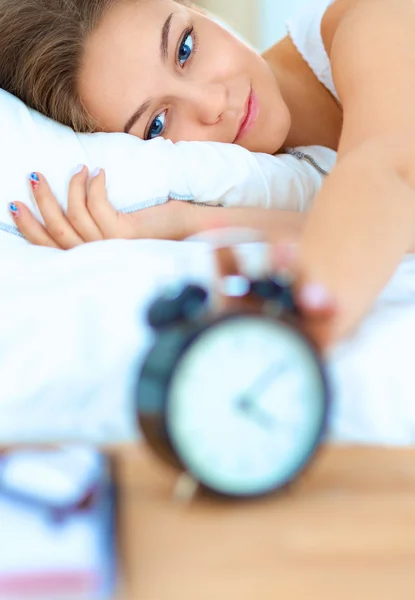 Una giovane donna che disattiva la sveglia la mattina — Foto Stock