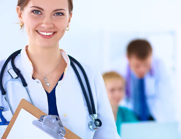 Attractive female doctor in front of medical group — Stock Photo, Image