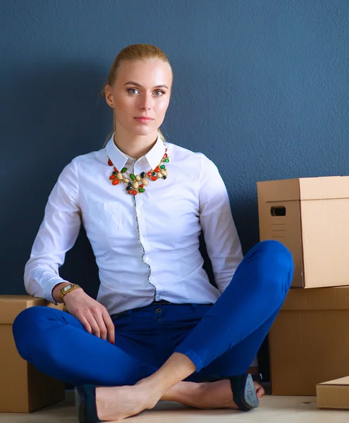 Mujer sentada en el suelo cerca de una caja con portátil —  Fotos de Stock