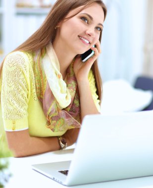 Elinde evrakları olan kadın masanın üstünde oturuyor.