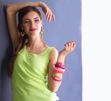 Karanlık duvarın yanında duran genç kadın.