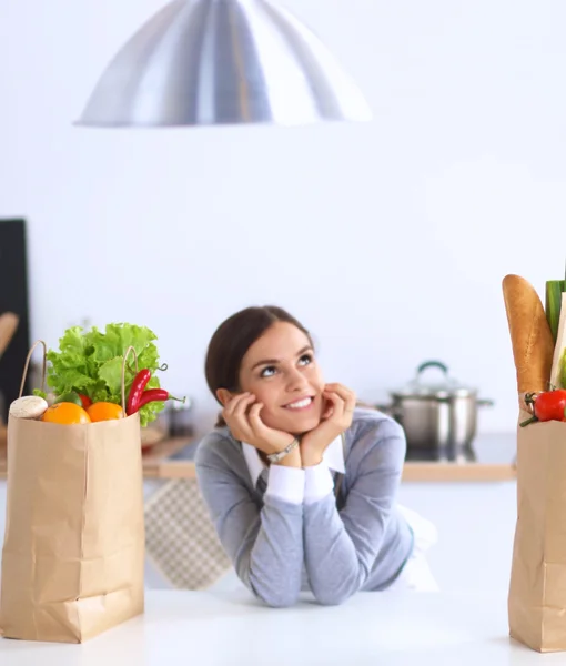 Portrait of a smiling woman cooking in her kitchen sitting — Stock Photo, Image