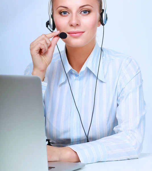 Portret piękne kobieta pracuje w jej biurko z zestawu słuchawkowego i laptopa — Zdjęcie stockowe