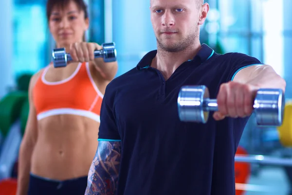 Schöne Frau im Fitnessstudio beim Training mit ihrem Trainer — Stockfoto