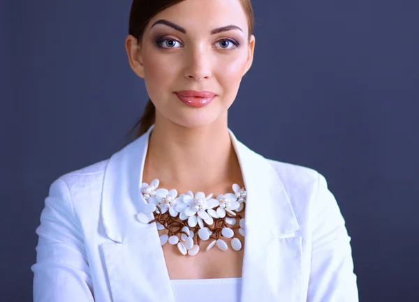 Porträt einer jungen Frau mit Perlen, stehend auf grauem Hintergrund — Stockfoto