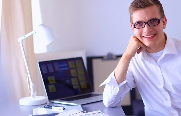 Ung affärsman arbetar på kontor, står nära skrivbord — Stockfoto