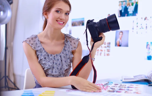 Mladá žena fotograf zpracování obrázků sedí na stole — Stock fotografie