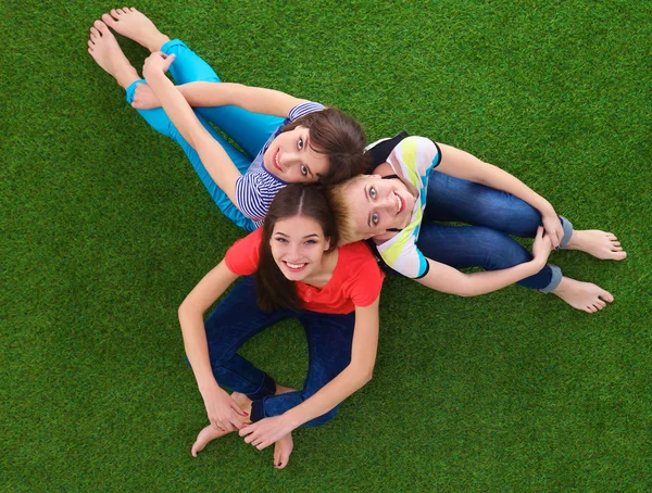 Mujeres jóvenes sentadas sobre hierba verde — Foto de Stock