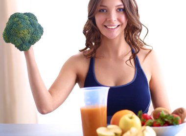 Genç ve güzel bir kadın mutfakta yemek pişiriyor.