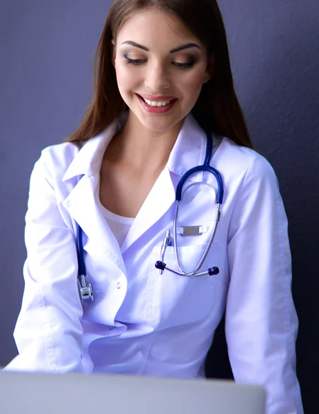 Жінка-лікар, що працює на сірому фоні — стокове фото