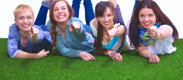 Four young women lying on green grass — Stock Photo, Image