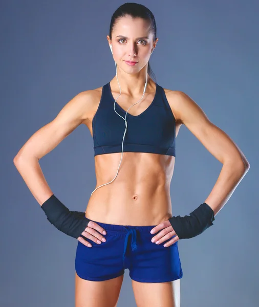 Musculosa joven posando en ropa deportiva sobre fondo negro —  Fotos de Stock