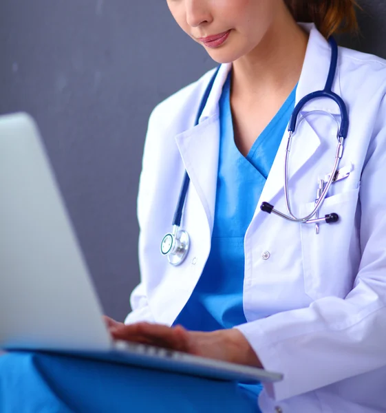 Female doctor working sitting on gray background — Stock Photo, Image