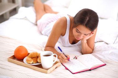 Bir günlük yazma yatakta yatan genç güzel kadın