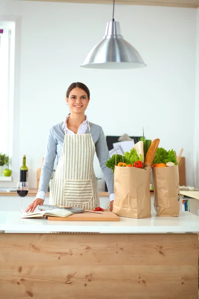 Porträtt av en leende kvinna som lagar mat i sitt kök — Stockfoto