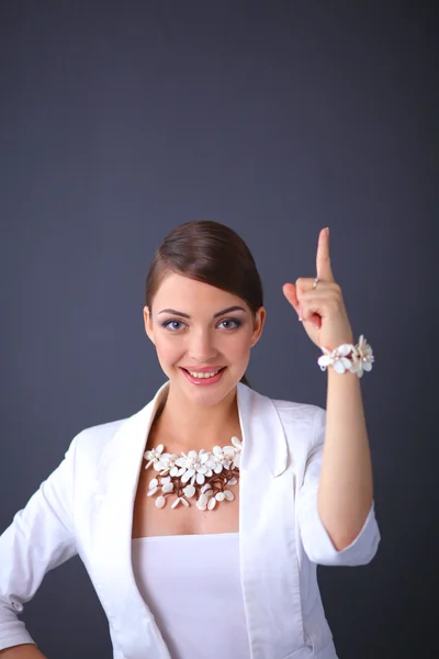 Portrait de jeune femme avec des perles, debout sur fond gris — Photo