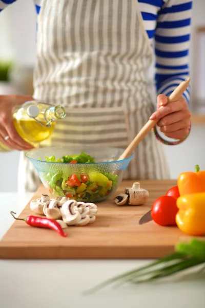 Giovane donna mescolando insalata fresca — Foto Stock