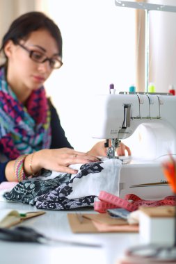 Çalışırken dikiş diken genç bir kadın.