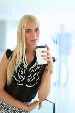 Ofiste bir fincan kahve ayakta tutan işkadını