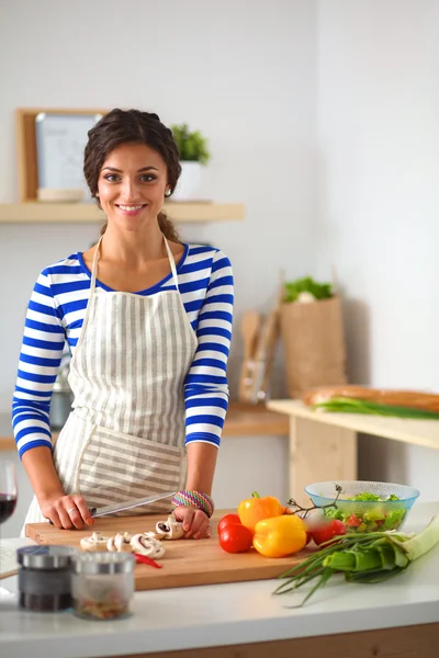 Young woman cutting vegetables in kitchen — Stock Photo, Image