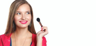 Genç güzel kadın elinde makyaj için fırça tutar