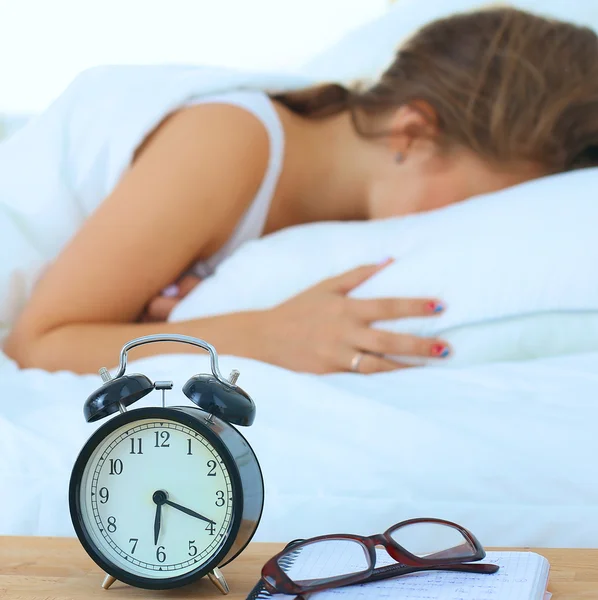 Mladá žena si ráno odkládá budík. — Stock fotografie