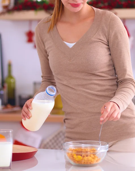 Leende attraktiv kvinna som äter frukost i köket interiör — Stockfoto