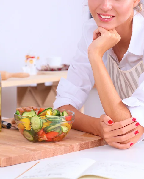 Lachende jonge vrouw voorbereiding salade in de keuken — Stockfoto