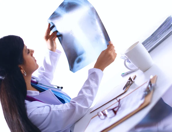 Jeune femme médecin étudiant l'image radiographique, assise au bureau — Photo