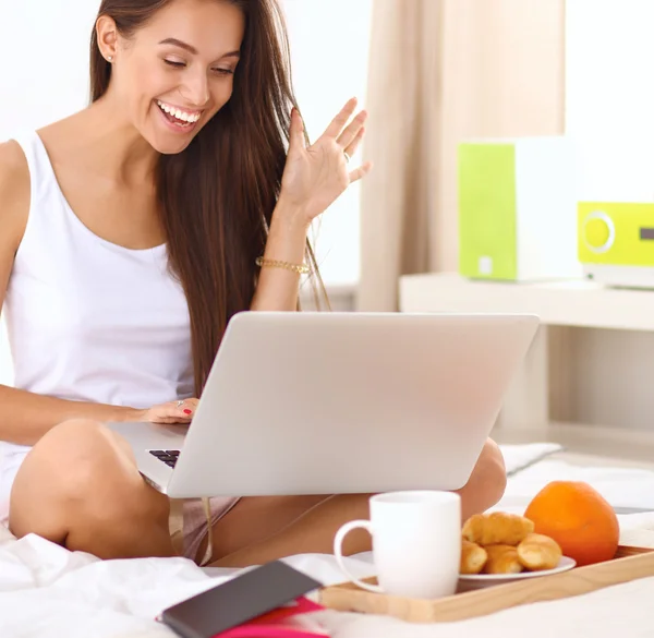 Jonge mooie vrouw zitten in bed — Stockfoto