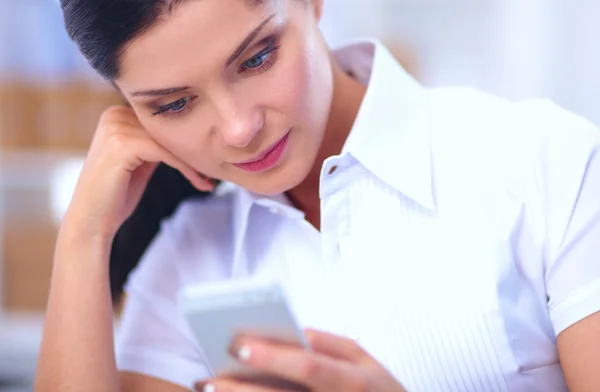 Femme d'affaires envoyer un message avec smartphone assis dans le bureau — Photo