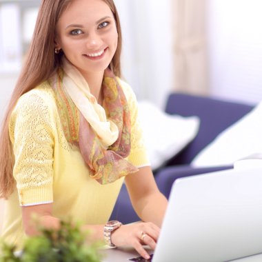 Elinde evrakları olan kadın masanın üstünde oturuyor.