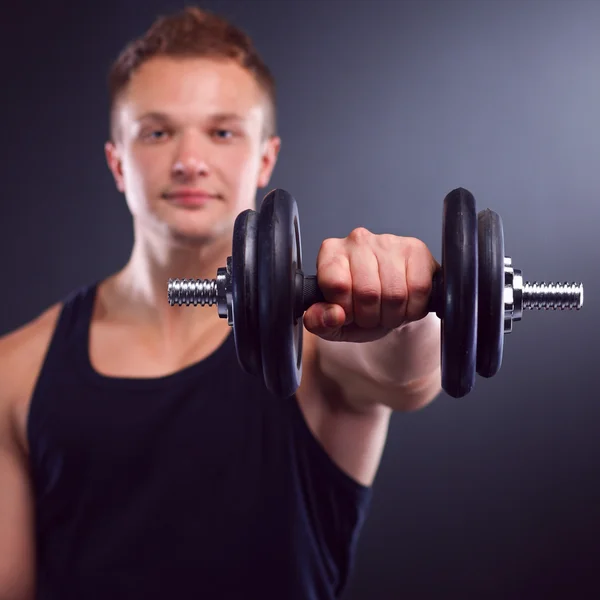 Bonito homem musculoso trabalhando com halteres — Fotografia de Stock