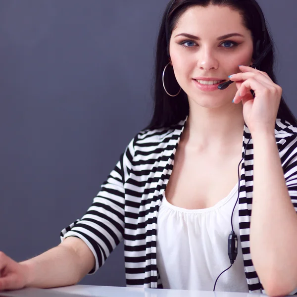 Όμορφη επιχειρηματίας που εργάζεται στο γραφείο της με ακουστικά και laptop — Φωτογραφία Αρχείου