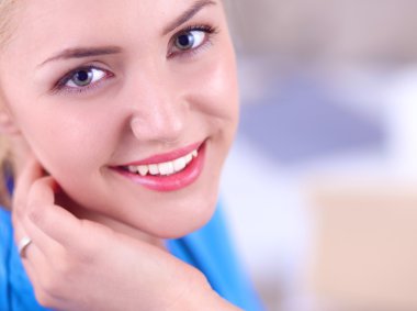 Kanepede dosyasıyla oturan mutlu genç bir doktorun portresi.