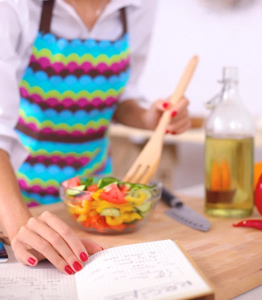 Leende ung kvinna blandar färsk sallad — Stockfoto