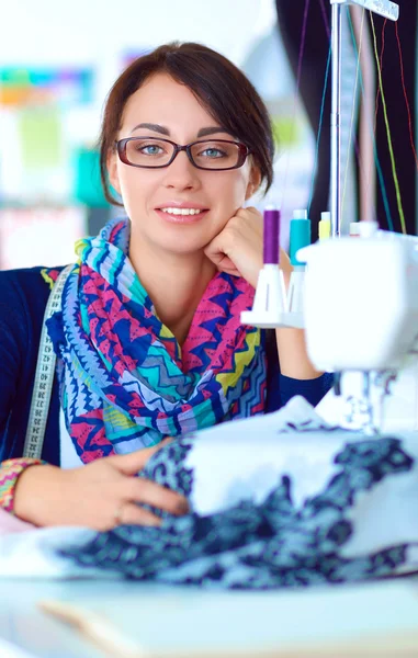 Mujer joven cosiendo sentado en su lugar de trabajo —  Fotos de Stock