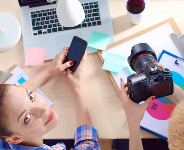 Female photographer sitting on the desk with laptop — Stock Photo, Image