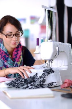 Çalışırken dikiş diken genç bir kadın.