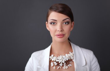 Boncuklar, gri arka plan üzerinde duran genç kadın portresi