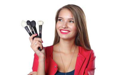 Genç güzel kadın elinde makyaj için fırça tutar