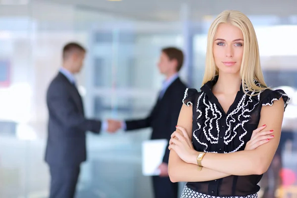 Zakenvrouw permanent op voorgrond in office — Stockfoto